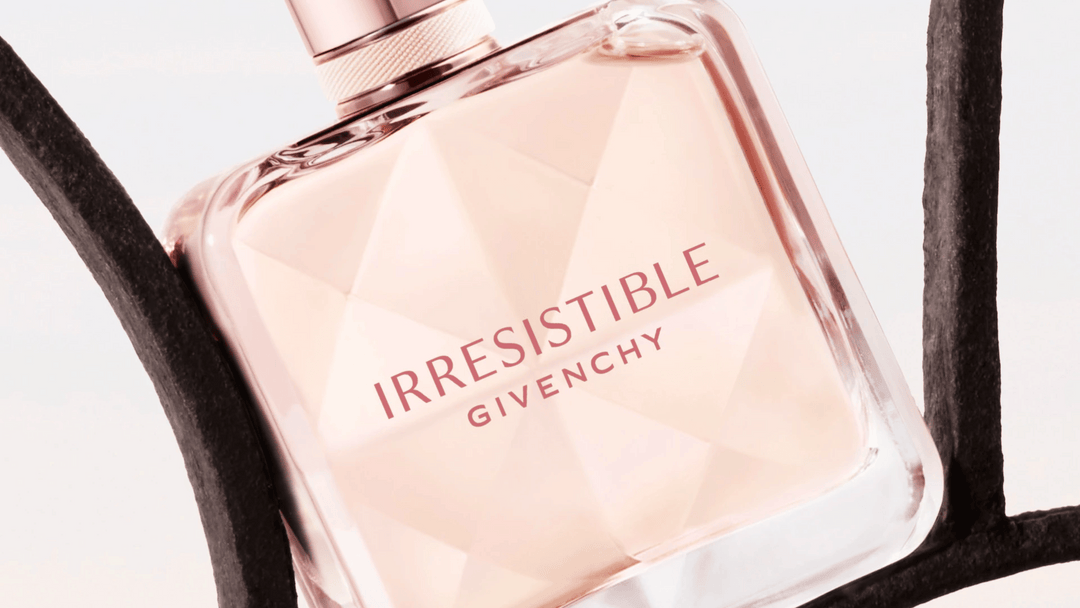 Bilden visar en parfymflaska från Givenchy med namnet "Irresistible". Flaskan är elegant med en geometrisk design i ljusrosa toner som reflekterar ljuset vackert.